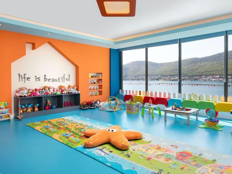 Colorful children's playroom with windows overlooking a lake and mountains.