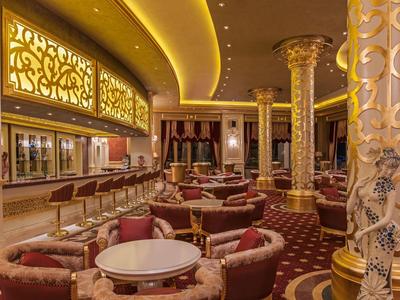 Luxurious hotel lounge area with elegant furniture and decorative golden columns.