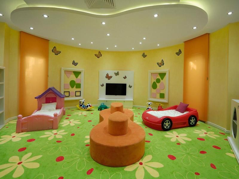Colorful kids' playroom with carpet, toy cars, and seating in soft colors.