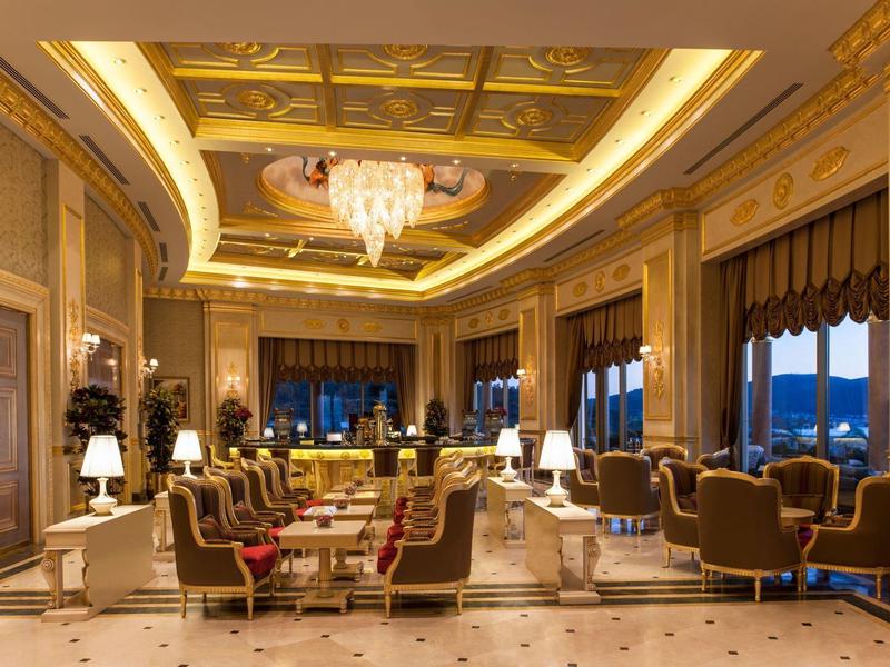 Luxurious hotel lounge with comfortable seating, chandelier, and warm lighting.