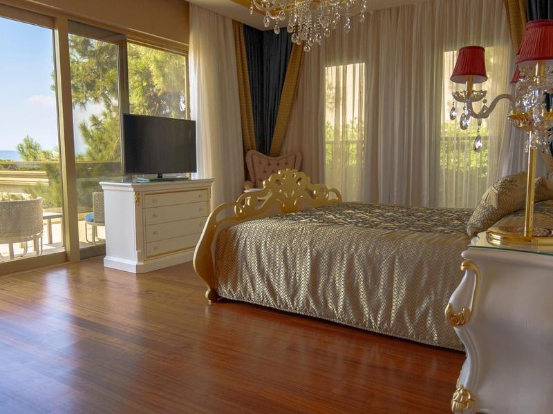 Luxurious bedroom with golden bed and sea view through large windows