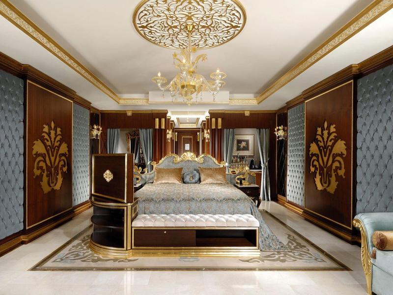 Elegant bedroom with luxury bed, gold accents, and chandelier.