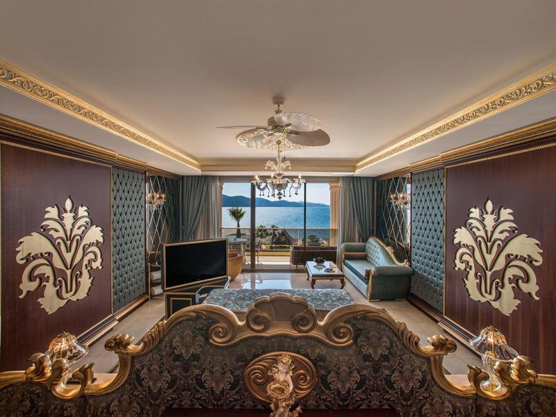 Luxuriously decorated hotel living room with sea view and elaborately ornate furniture.