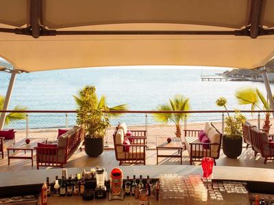 Pohled na terasu s židlemi a stoly u moře za slunečného počasí