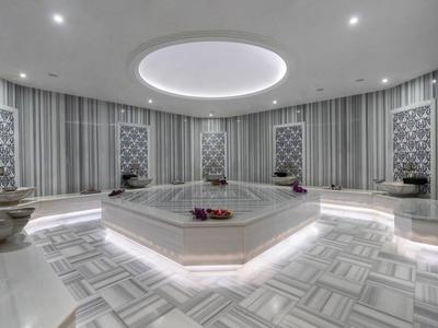 Moderne ronde Turkse hammam met centrale verwarmde steen en sfeerverlichting.