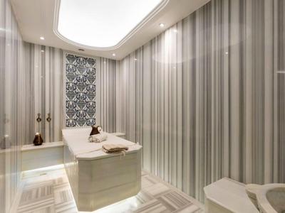 Moderne wellnessruimte met massagetafel, zachte verlichting en gestreept wandontwerp.