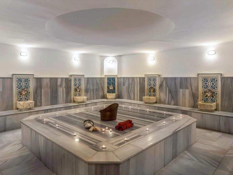 Traditionele Turkse hammam met marmer en warm licht.
