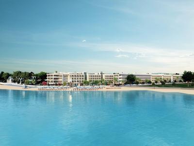 Große Hotelanlage mit Pool und Sandstrand unter hellem Himmel.