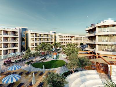 Hotelanlage mit mehreren Gebäuden, Garten, Pool und Sonnenliegen unter blauem Himmel.