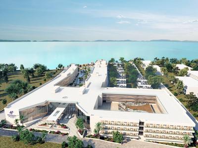 Moderner Hotelkomplex mit weißen Gebäuden und Pool, neben einem großen blauen See unter klarem Himmel.