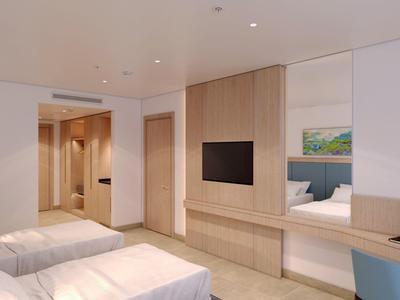 Modern eingerichtetes Hotelzimmer mit zwei Betten, TV und gemütlichem Ambiente.