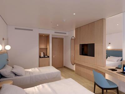 Modernes Hotelzimmer mit zwei Einzelbetten, Holzvertäfelung und Sitzbereich mit Stuhl.