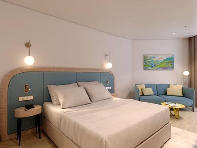 Modern eingerichtetes Hotelzimmer mit großem Bett, Sitzecke und minimalistischer Dekoration.