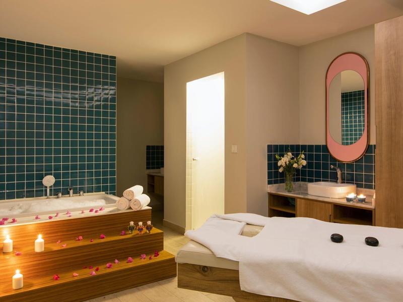 Gezellige spakamer met jacuzzi, kaarsen, massagetafel en moderne inrichting.