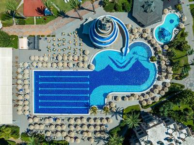 Aerial view of a hotel pool with different swimming areas and surrounding sun umbrellas