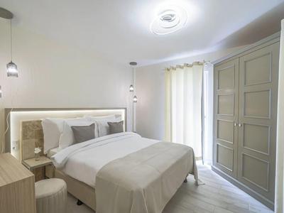 Camera da letto moderna con letto matrimoniale, armadio e toni beige morbidi.