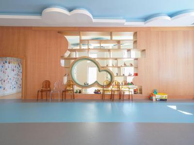 Moderner Hotellobbybereich mit Holzverkleidung, Formenregal und Stühlen vor blauer und grauer Bodenfläche.