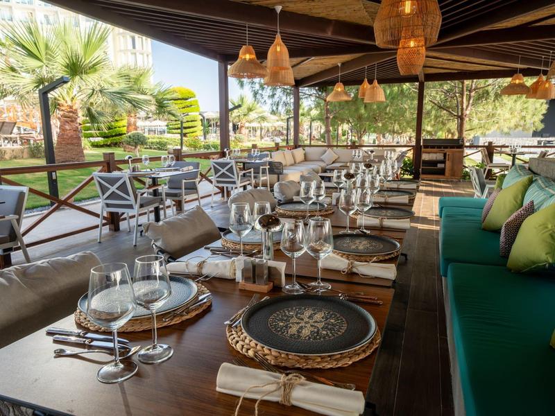 Otwarta jadalnia z elegancko nakrytymi stołami i jasną, naturalną dekoracją.