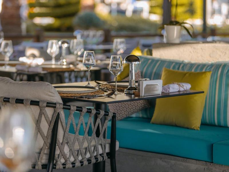 Wnętrze restauracji z wygodnymi miejscami do siedzenia i elegancko nakrytymi stołami.