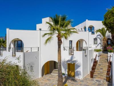 Edificio dell'hotel bianco in stile mediterraneo con cielo azzurro e palme