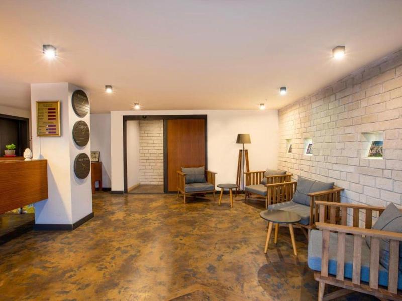 Area lounge accogliente dell'hotel con mobili in legno e illuminazione calda.