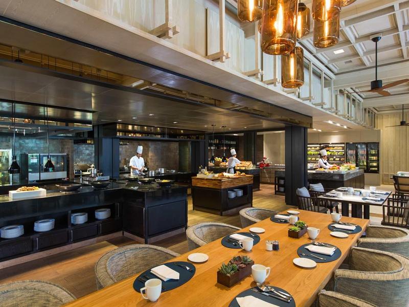 Elegant restaurant with wooden tables, set plates, and modern black and white design.