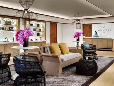 Moderní hotelová lobby se sezením, kobercem a orchidejemi.