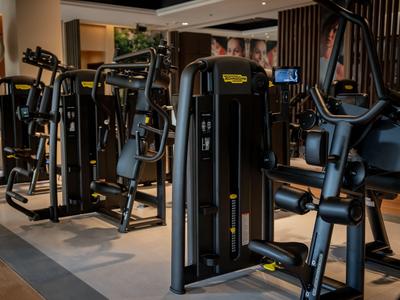 Moderní posilovna s několika posilovacími stroji v hotelu.