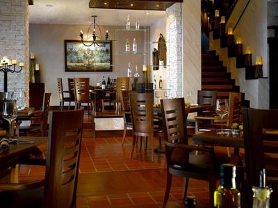 Gemütlicher Restaurantbereich mit Holztischen und Stühlen in warm beleuchtetem Ambiente.