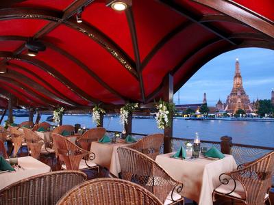 Rotes überdachtes Restaurant mit Blick auf den Fluss und Wat Arun in Bangkok.