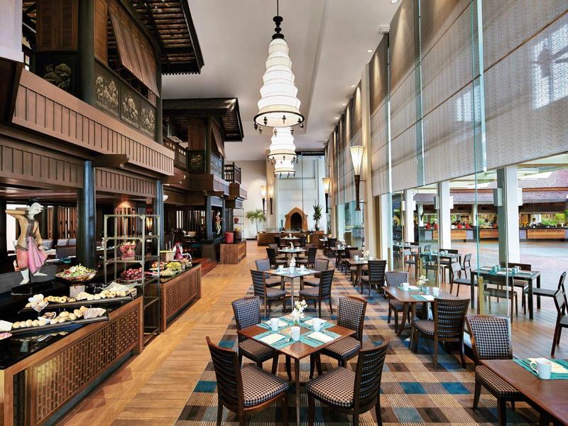 Modernes Hotelrestaurant mit langen Fensterfronten, Esstischen und Buffetbereich.