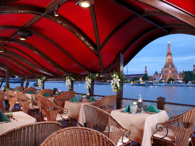 Rotes überdachtes Restaurant mit Blick auf den Fluss und Wat Arun in Bangkok.