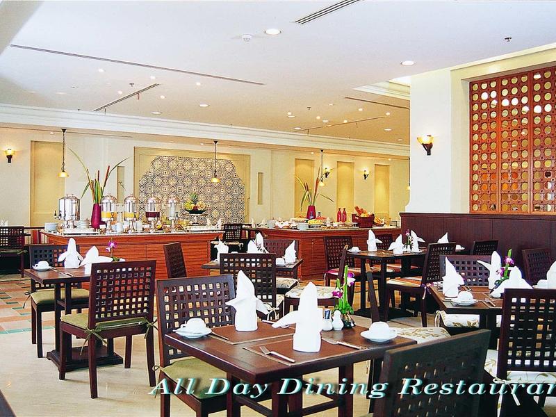 Ein helles, modernes Restaurant mit dunklen Holzstühlen, gedeckten Tischen und dezenten Wanddekorationen.