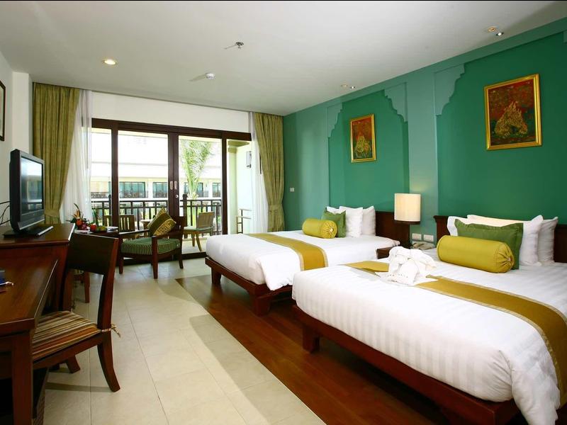 Hell eingerichtetes Hotelzimmer mit zwei Einzelbetten, grün gestrichener Wand und Balkon mit Blick.