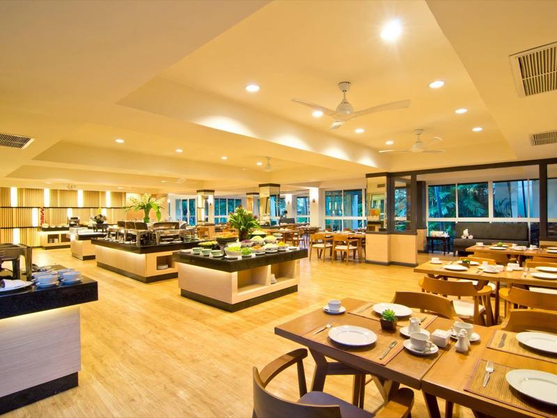 Helles, modernes Restaurant mit Holzboden, gedeckten Tischen und großzügigem Buffetbereich.