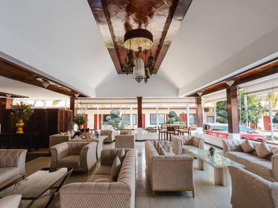 Helle Hotel-Lounge mit bequemen Sesseln, großen Fenstern und moderner Einrichtung.