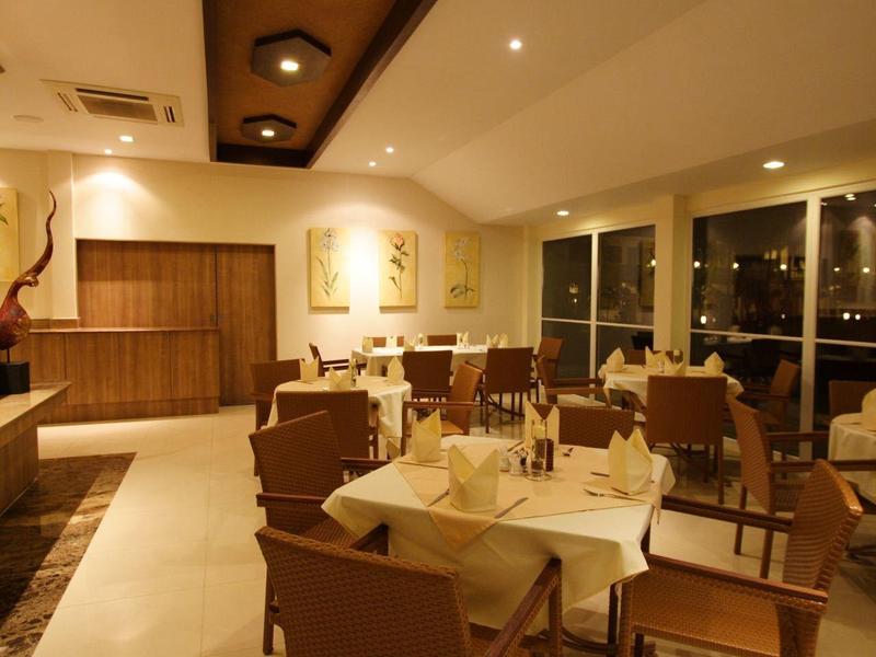 Elegantes Restaurant mit gedeckten Tischen, braunen Stühlen und warmem Deckenlicht.