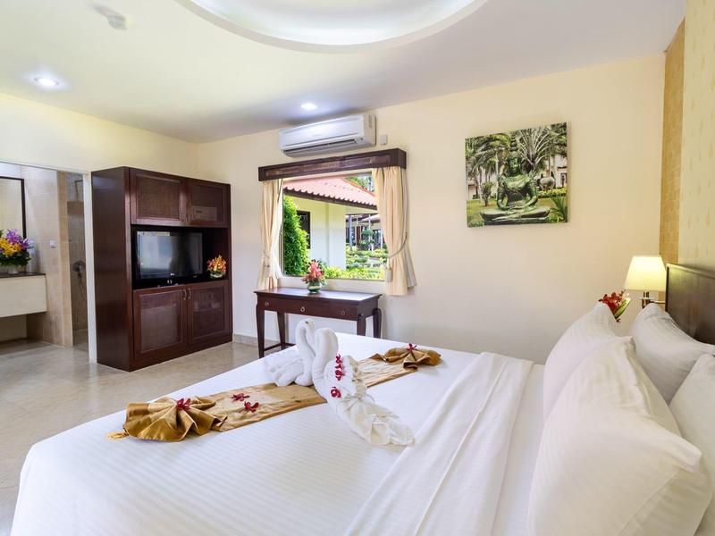 Helles Schlafzimmer mit großem Bett, Spiegelkommode, Klimaanlage und moderner Einrichtung.