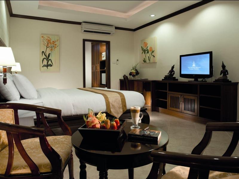 Gemütliches Hotelzimmer mit Doppelbett, Holzmöbeln, TV und dekorativen Wandbildern.