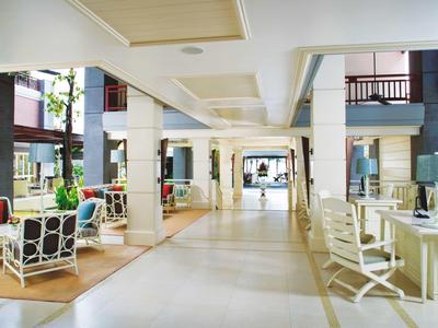 Bright hotel lobby with seating areas and large windows allowing plenty of natural light.