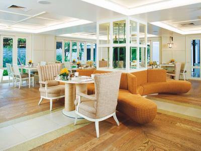 Helles Hotelrestaurant mit modernen Möbeln und großen Fenstern