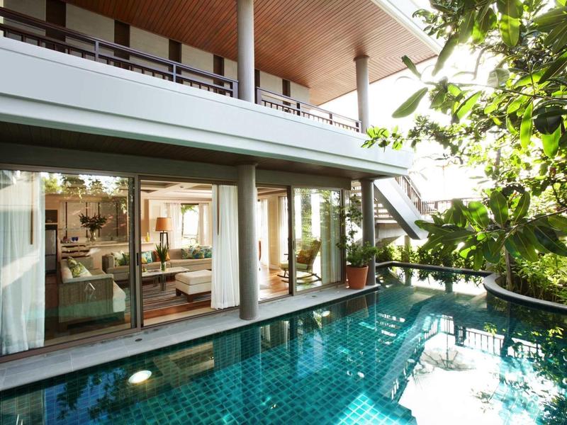 Modern hotel room with direct access to a private pool and abundant greenery.