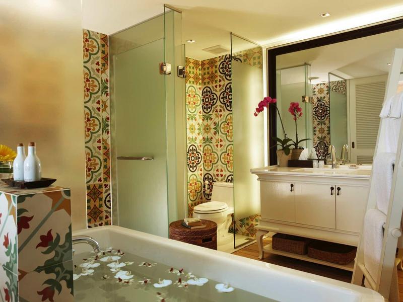 Elegant bathroom with glass shower enclosure, decorative tiles, and freestanding bathtub.
