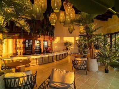 Gemütliche Hotellobby mit Korbsesseln und warmem, gelbem Licht.