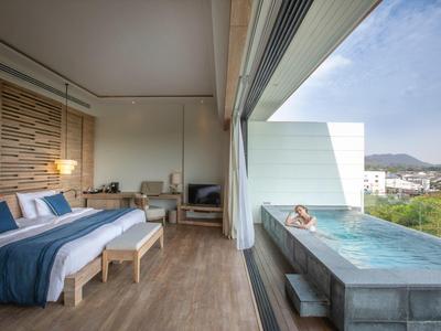 Camera d'hotel moderna con piscina infinity aperta e vista sulle montagne alla luce del giorno