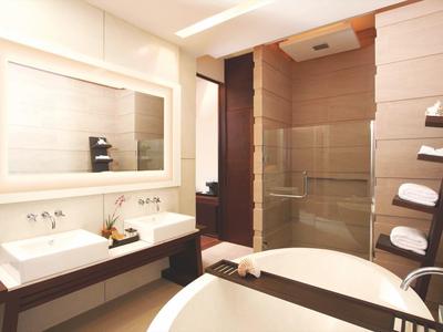 Moderne badkamer met dubbele wastafel, grote spiegel en badkuip met glazen douche.