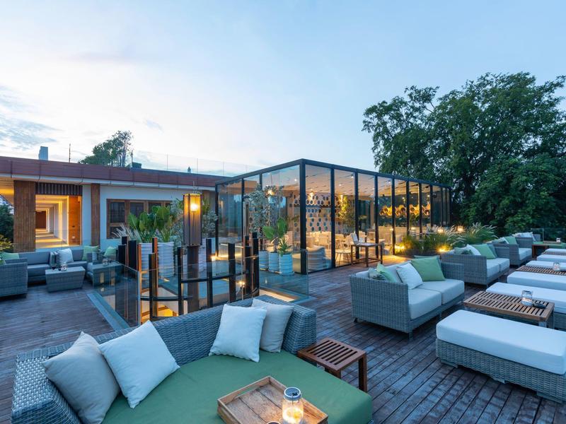 Moderne dakterras met gezellige zithoeken en glazen wanden in een hotel