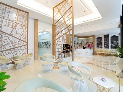 Moderner Hotel-Lobbybereich mit Sitzgelegenheiten, dekorativen Trennwänden und hellem Design.