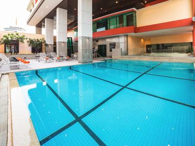 Moderner Innenpool in einem Hotel mit Glaswänden und Liegestühlen am Rand.