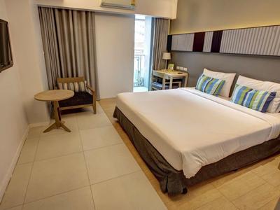 Modernes Hotelzimmer mit Doppelbett, Sidechair, Fernseher und Balkon.